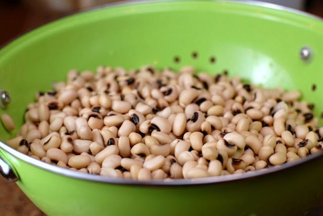 A green bowl filled with black eyed peas
