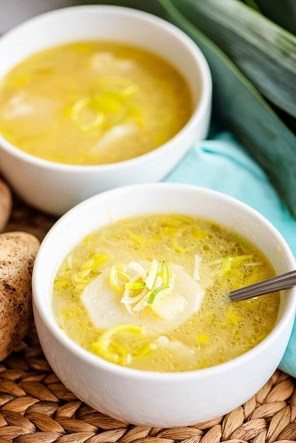 two white bowls of potato leek soup