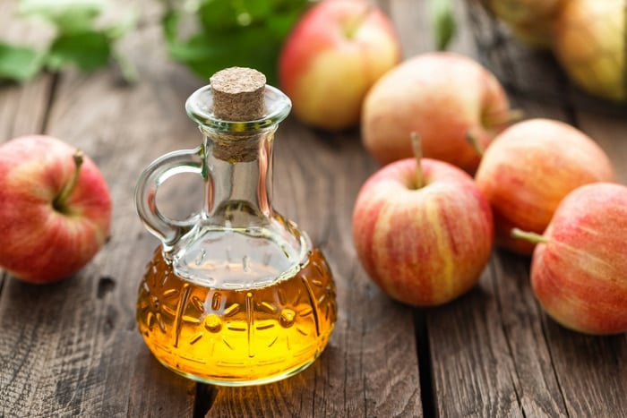 Apple cider vinegar in carafe with apples