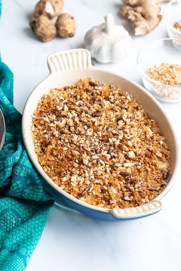 Scalloped Sunchokes with crunchy nut and breadcrumb topping in pan 