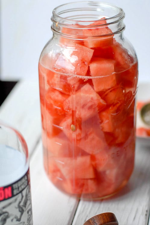 Mason jar filled with watermelon chunks and tequila