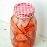 A close up of jar of strawberry vodka