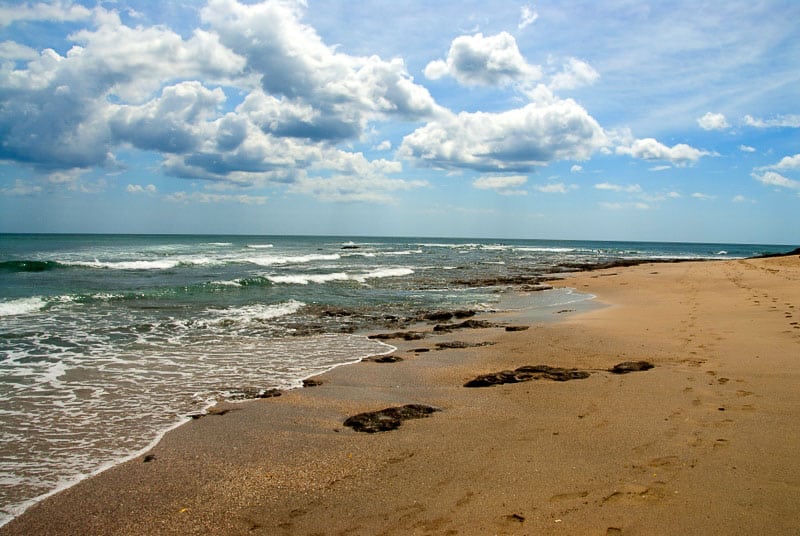 Costa Rican beah with blue skies and billowy white clouds