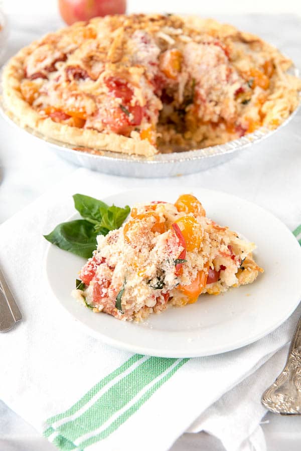 Fresh Savory Tomato Pie and slice on plate with basil sprig