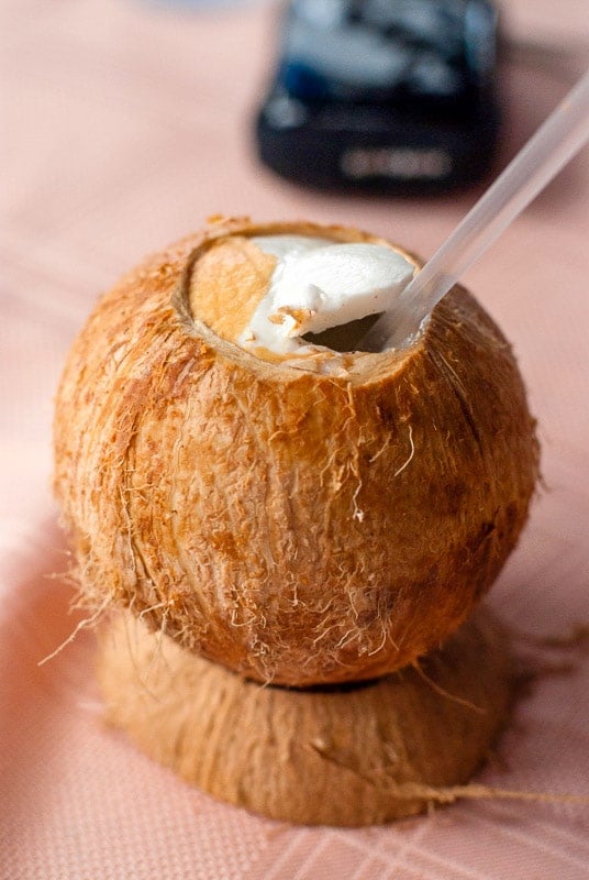 Freshly opened coconut with straw to drink the milk