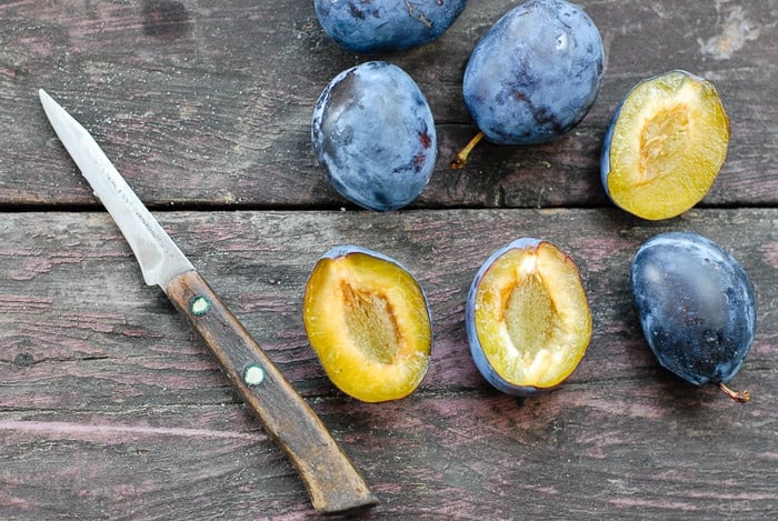 sliced italian plums with knife