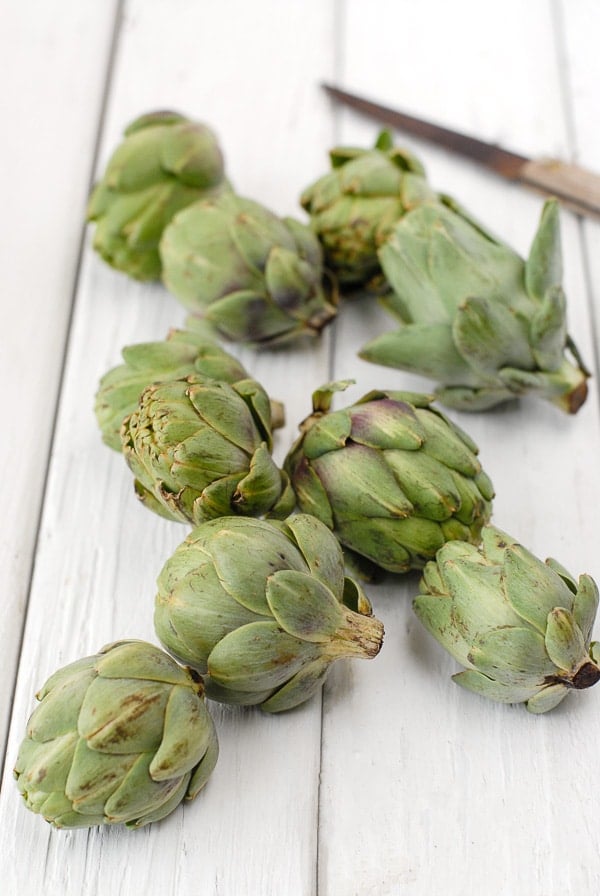 baby artichokes on white wood slats