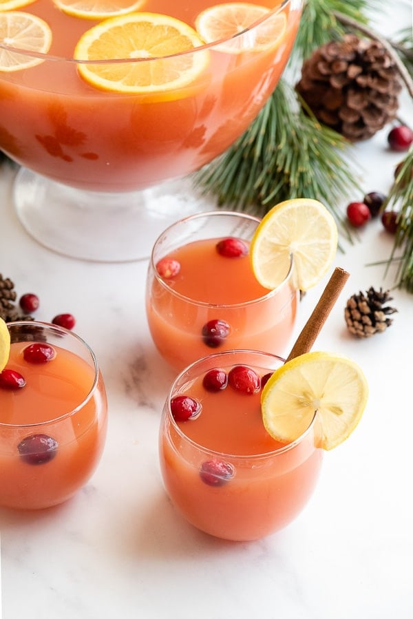 Glasses of warm Wassail with cranberries and lemon slices