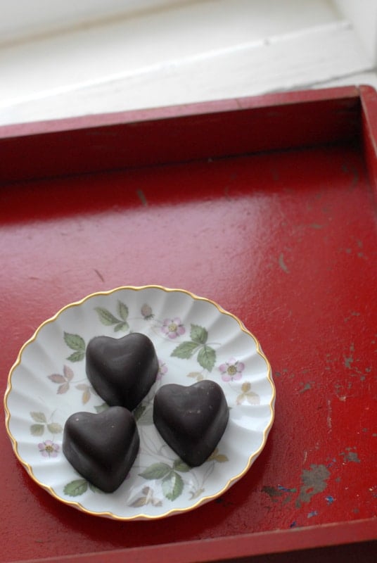 three chocolate hearts on floral china plate