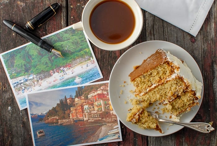 slice of Italian Cream Cake with post cards and a fountain pen