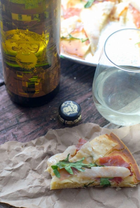 pizza slice with bite taken and wine bottle