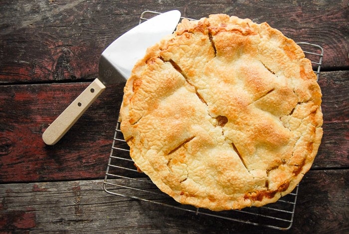 Pear pie on cooling rack with pie cutter