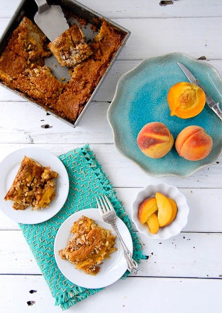 Fresh Peach Sour Cream Coffee Cake with servings and peaches on a plate