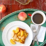 breakfast in bed tray holding a plate of Baked Pancakes with Sauteed Peaches