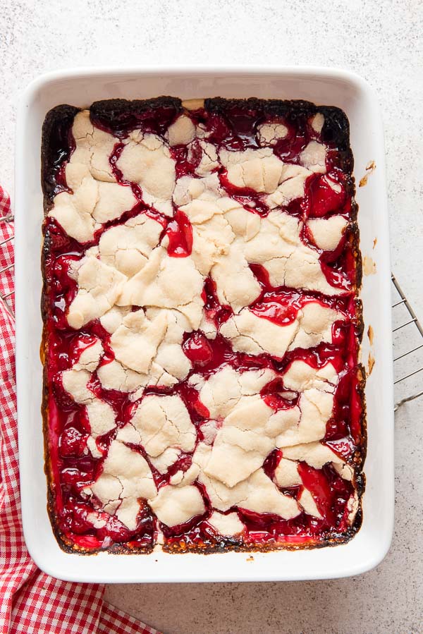 Freshly baked Raspberry Pandowdy, an Americana dessert, in a white baking dish with wire cooling rack