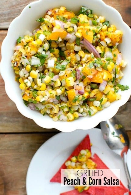 Sweet and spicy freshly made Grilled Peach and Corn Salas in a white bowl with red corn chips 