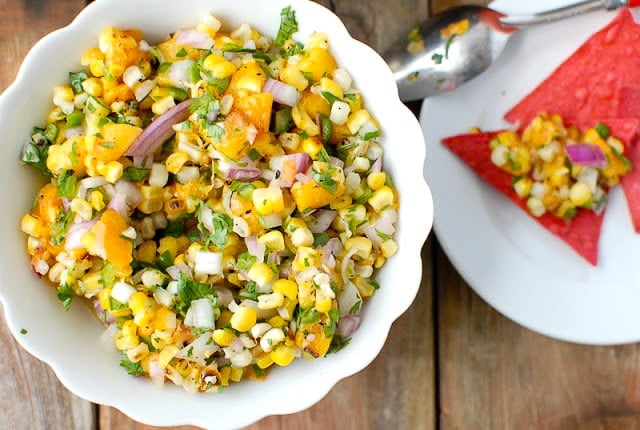 Grilled Peach and Corn Salsa with red tortilla chips on a white plate 