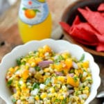 Grilled Peach and Corn Salsa in a white ruffle-edged with red corn tortilla chips, bottled lemonade