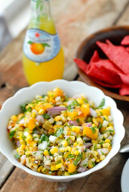 Grilled Peach and Corn Salsa in a white ruffle-edged with red corn tortilla chips, bottled lemonade 