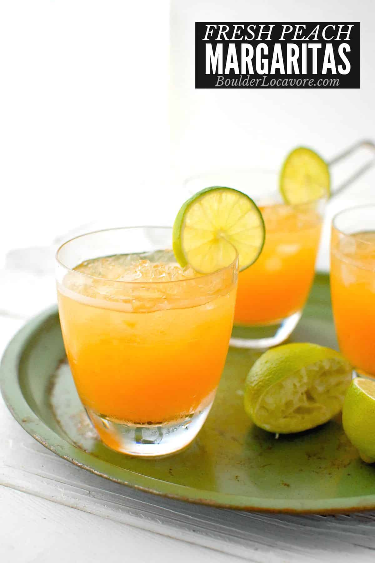 peach margaritas on a green tray.