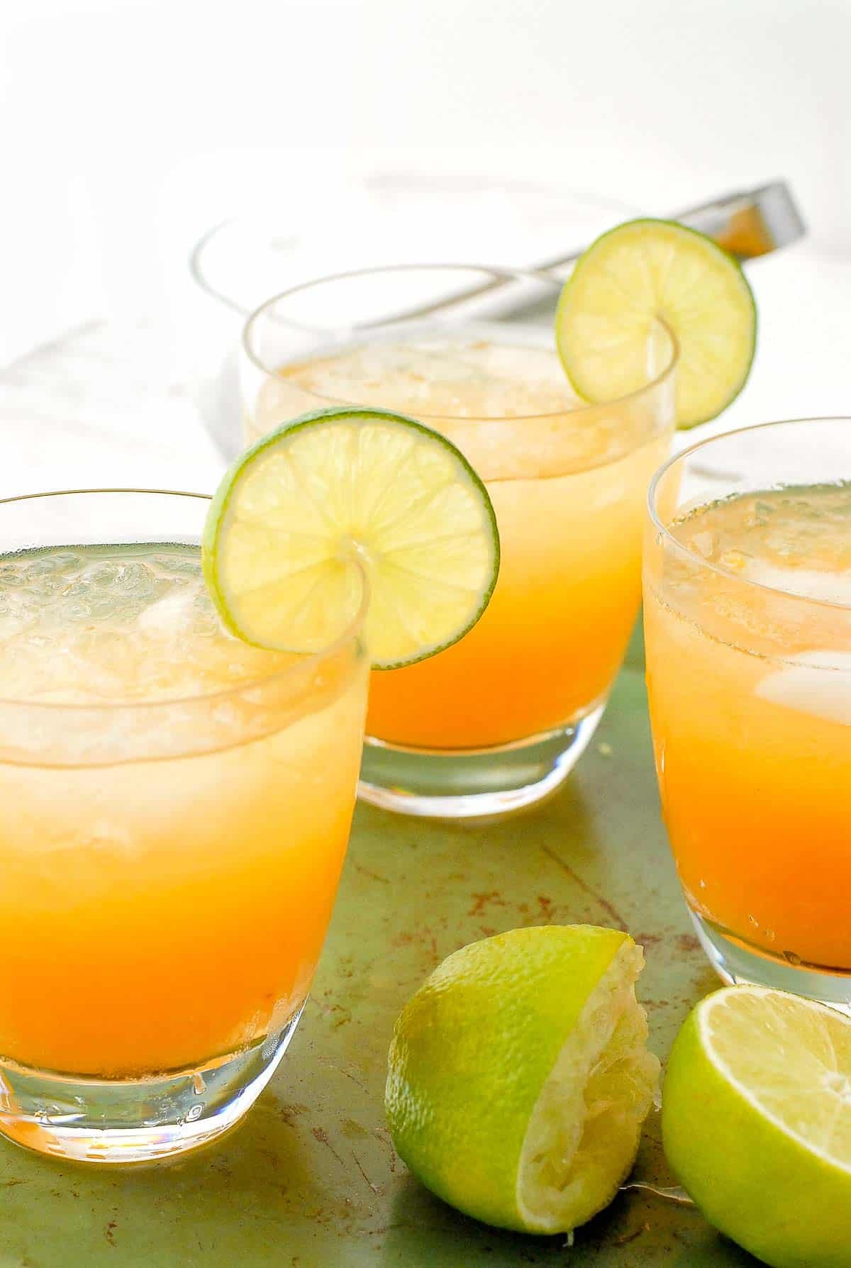 peach margaritas on vintage green tray by window.