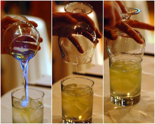 pouring flaming absinthe into cocktail