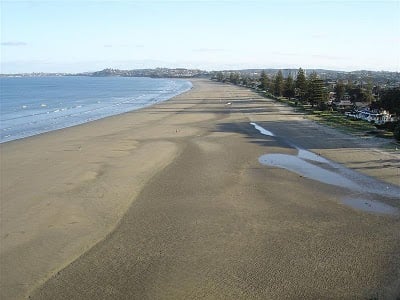 A sandy beach next to a body of water