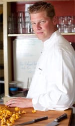 Alex Seidel standing in front of a table