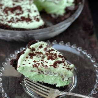 Single slice of Grasshopper Pie recipe on a plate with whole pie in background