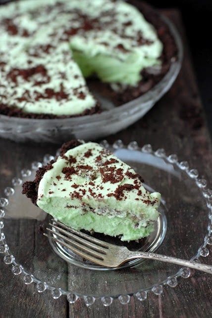 Single slice of Grasshopper Pie recipe on a plate with whole pie in background