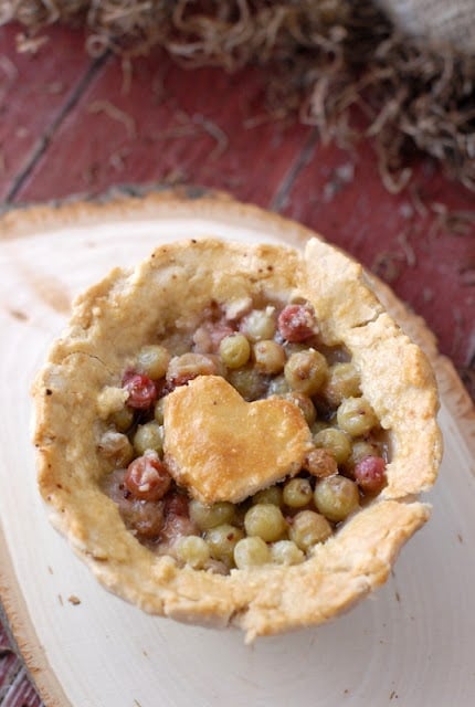 A close up of a gooseberry pies with heart dough on top