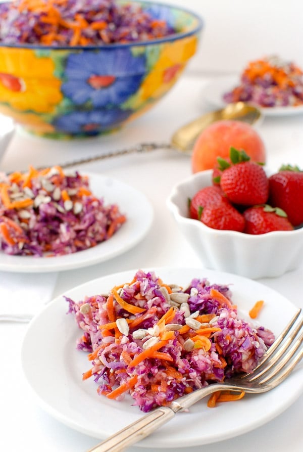 colorful slaw with red cabbage and carrot with peach-strawberry dressing on white plates