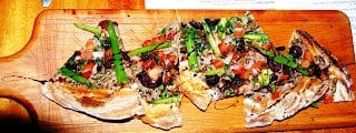 A flatbread pizza sitting on top of a wooden cutting board