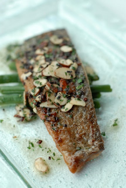 sauteed trout with slivered almond on white plate