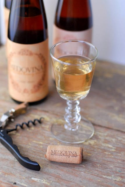 A close up of a bottle and a glass of mead