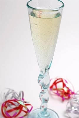 A glass cup on a table, with Wine