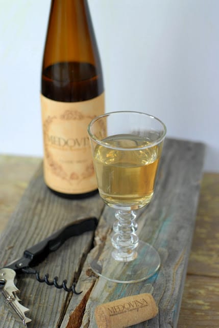 A bottle of mead sitting on top of a wooden table