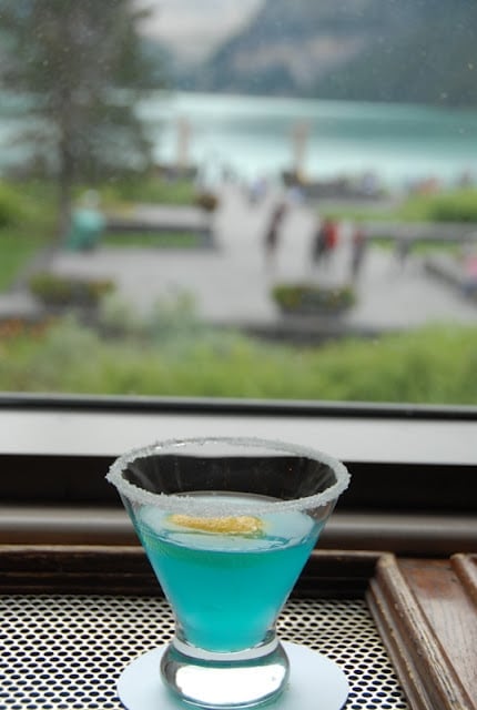 blue cocktail on a table in front of window