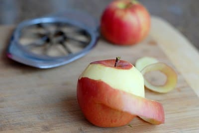 peeling an apple with cutter in background