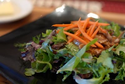 A close up of a plate of food on a table, with Salad