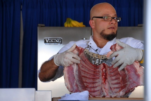 chef carving meat holding up ribs