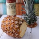 A pineapple on a wooden cutting board