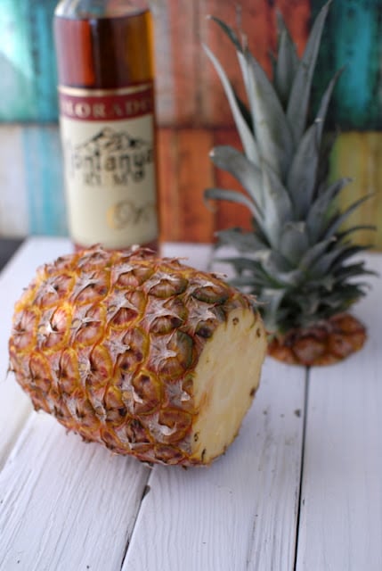 A pineapple on a wooden cutting board