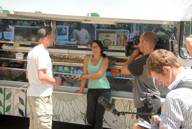 A group of people standing around a food truck