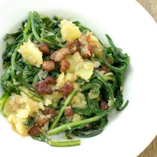 Warm Dandelion and Bacon salad in a white salad bowl