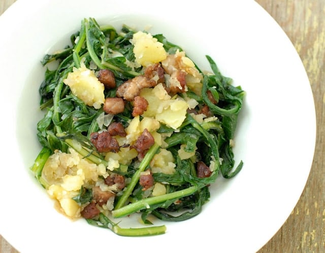 Warm Dandelion and Bacon salad in a white salad bowl