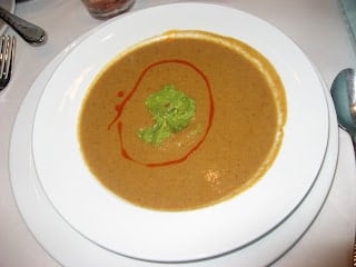 A bowl of food on a plate, with Soup and Leek