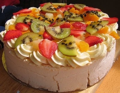 A slice of cake on a plate, with Cream and Pavlova