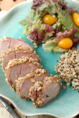 slices of pork tenderloin with peanuts on outside on plate