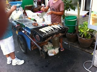 A group of people preparing food in a kitchen, with Street and Vendor